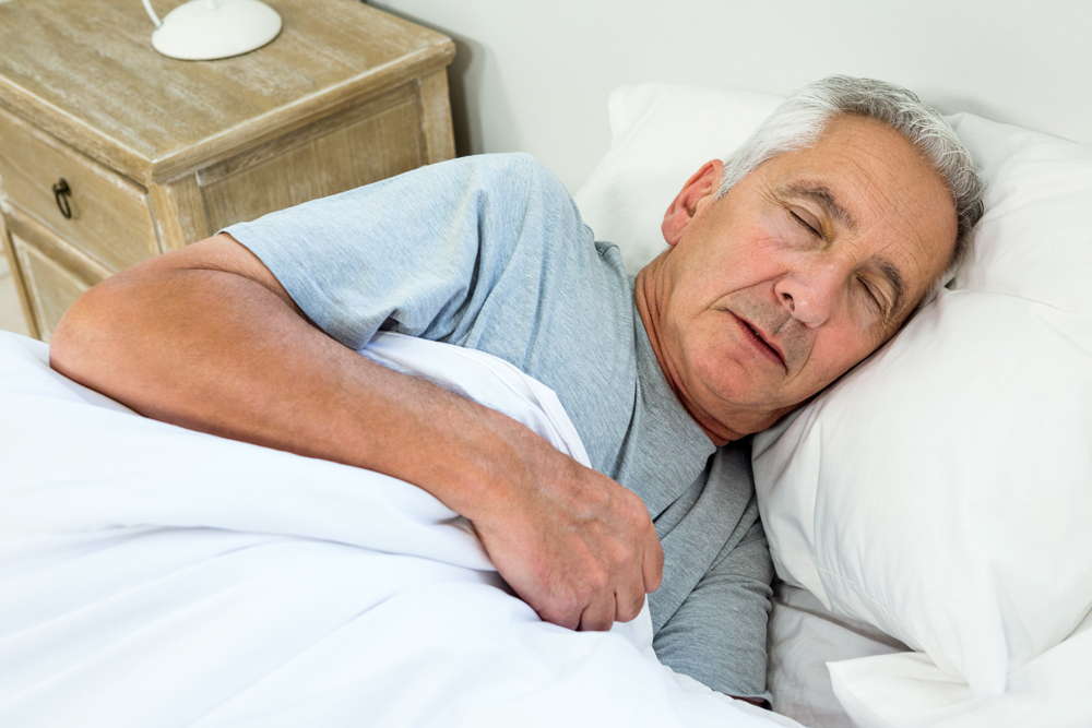 Schlafender Patient mit leicht geöffnetem Mund, symbolisiert das Schlafapnoe-Syndrom und die benötigte CPAP-Therapie.